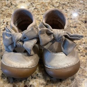 Stride rite, light tan/ gold toddler shoes, with a bow on the front.